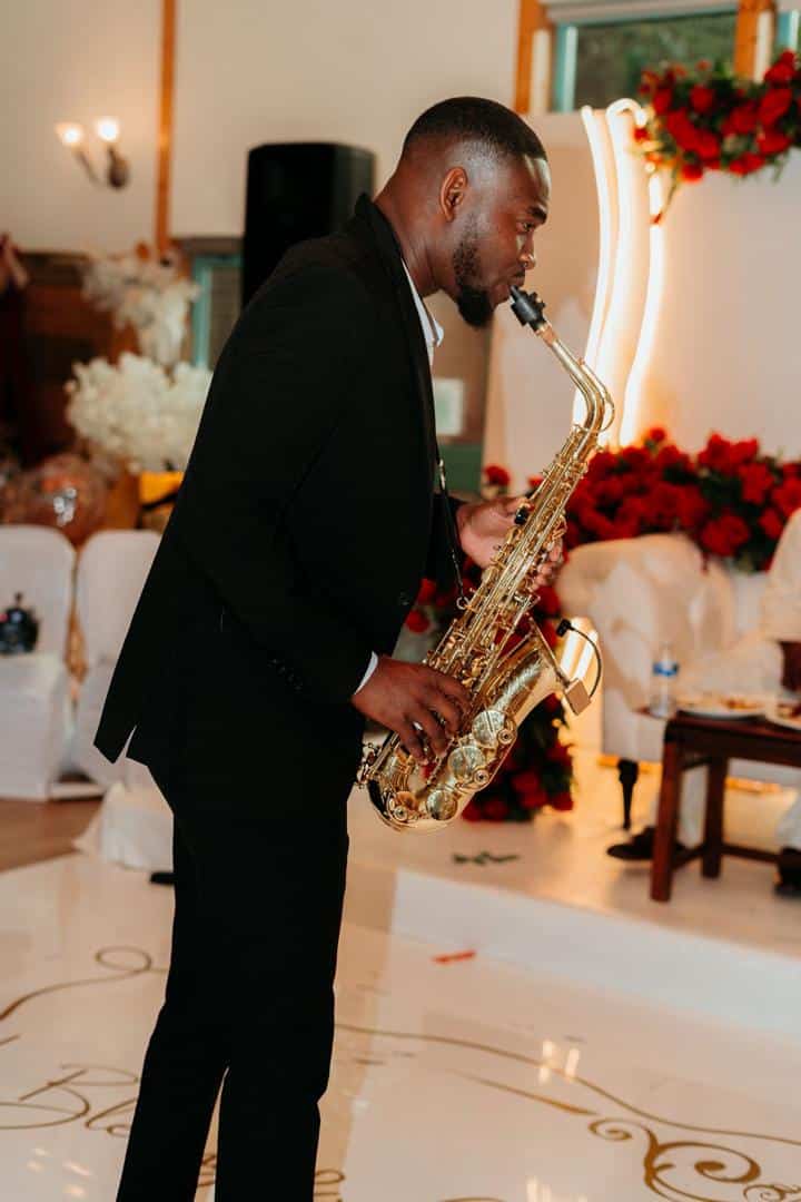 Temitope Oladipupo playing saxophone at event.